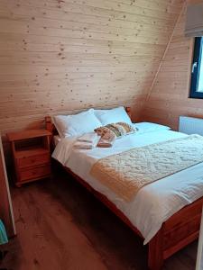 ein Schlafzimmer mit einem Bett und einer Holzwand in der Unterkunft CarpatinA Rustic House in Runcu