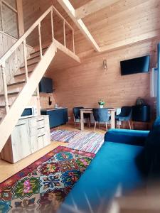 ein Wohnzimmer mit einem blauen Sofa und einer Treppe in der Unterkunft CarpatinA Rustic House in Runcu