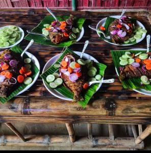 a group of plates of food on a wooden table at Jyoti Home Bamboo Garden Lodge in Majuli