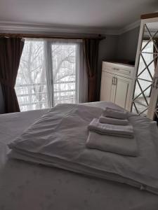 - un lit avec 3 serviettes et une fenêtre dans l'établissement O'CHENA AKYUZ PAR in UZUNGÖL, à Çaykara