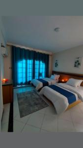 - une grande chambre avec 2 lits et une fenêtre dans l'établissement Ajami Hotel Armed Forces Apartments, à Alexandrie