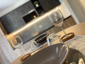 dois copos de vinho sentados num balcão ao lado de um lavatório em Casa di Maggie 2 - Comfort e natura tra Pinzolo e Campiglio em Carisolo mais 31 fotografias