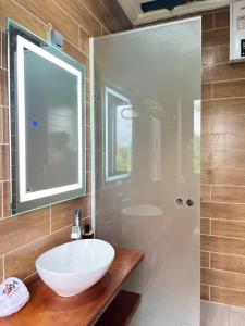 a bathroom with a white sink and a shower at SKY KENAKO HOTEL in Kribi