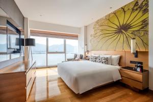 ein Schlafzimmer mit einem großen weißen Bett und einem großen Fenster in der Unterkunft Wingtech Hotel in Huangshi