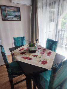 a table with a table cloth with flowers on it at Jacky's Apartament - Апартамент в Свети Влас in Sveti Vlas