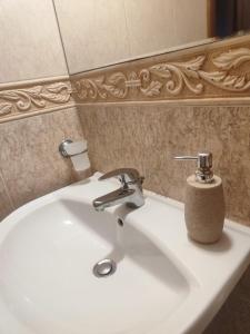 a white bathroom sink with a soap dispenser on it at Jacky's Apartament - Апартамент в Свети Влас in Sveti Vlas
