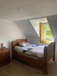 een slaapkamer met een bed en een raam op zolder bij charme, calme et authenticité côte des légendes in Plouider