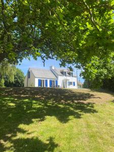 een huis op een grasheuvel met een boom bij charme, calme et authenticité côte des légendes in Plouider