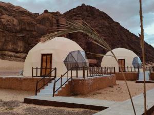 dos tiendas de campaña en el desierto con una montaña en star's bubble tents, en Wadi Rum