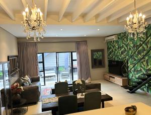 a living room with a couch and a table and a television at Meerendahl Luxury Apartments at Heritage Square in Durbanville