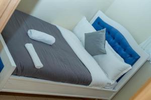 Una cama con almohadas azules y blancas. en Eldoret home, Q10 unity homes, en Eldoret