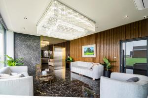 a living room with white furniture and a large chandelier at YSW Hotel Lopburi in Ban Khok Krathiam