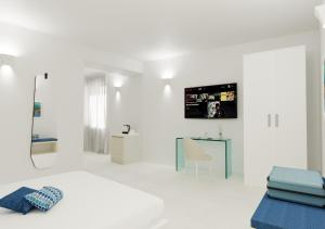 a white bedroom with a bed and a tv on a wall at Amalfi Suite Boutique Hotel in Amalfi