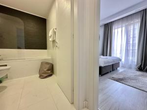 Un baño con bañera y un dormitorio con cama. en Double Studio A106 StayInn by Cosmopolis, en Creţuleasca