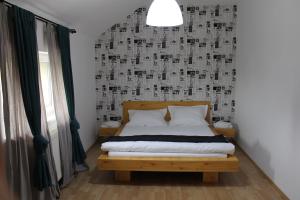 a bedroom with a bed with a black and white wall at News Apartment in Bucharest