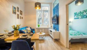 una sala de estar con una habitación con una cama y una mesa en BaySide Apartments City Center en Gdansk