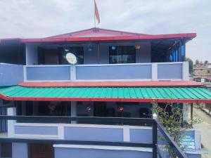 a building with a green awning next to a street at The Heavens in Almora