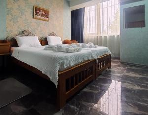 1 dormitorio con 1 cama grande y toallas. en West Star Hotel en Kutaisi