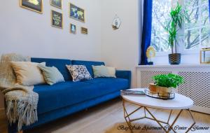a blue couch in a living room with a table at BaySide Apartments City Center in Gdańsk
