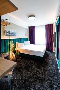 ein Schlafzimmer mit einem großen Bett in einem Zimmer in der Unterkunft Business Hotel Conference Center & Spa in Târgu Mureș