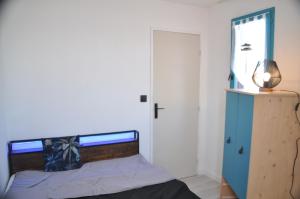 um quarto com uma cama e um armário azul em Ker Armelle em Le Barcarès
