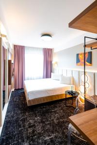 um quarto de hotel com uma cama e uma grande janela em Business Hotel Conference Center & Spa em Târgu-Mureş