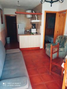 a living room with a couch and a kitchen at Complejo Godoy in Losar de la Vera