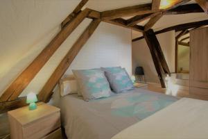 ein Schlafzimmer mit einem Bett im Dachgeschoss in der Unterkunft Gite de la Bouvotte in Neuville-sur-Vanne
