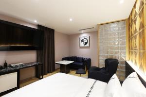 ein Hotelzimmer mit einem Bett, einem Tisch und Stühlen in der Unterkunft Gaeul Hotel in Chungju