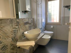 bagno con lavandino e servizi igienici di Appartamento La Pineta a Marina di Cecina