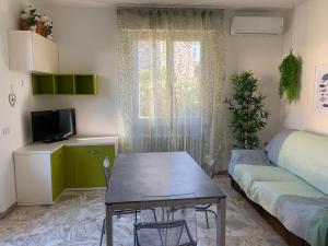 ein kleines Wohnzimmer mit einem Tisch und einem Sofa in der Unterkunft Appartamento La Pineta in Marina di Cecina
