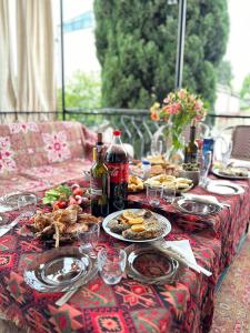 uma mesa com pratos de comida e garrafas de vinho em Nina’s Sweet Home em Tbilisi