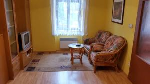a living room with two chairs and a table and a television at Apartment Kamenná in Brno