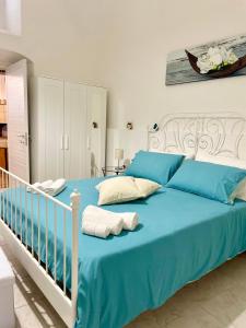 1 dormitorio con cama azul y cuna blanca en Mena Holiday House en Sant'Agnello