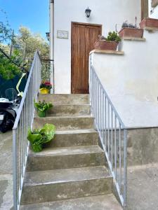 una escalera que conduce a una casa con puerta de madera en Mena Holiday House en Sant'Agnello