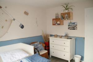 a bedroom with a white bed and a dresser at FeWo Zwischen Nord- und Ostsee in Dörpstedt