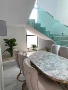 uma sala de jantar com uma mesa de mármore e cadeiras em Coin de luxe em Cotonou