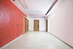 an empty corridor with red walls and a ceiling at FabHotel Capital Inn in Ghaziabad