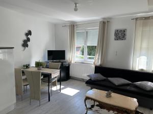 a living room with a couch and a table at Suite chez willi in Niederschaeffolsheim