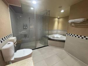 a bathroom with a shower and a toilet and a tub at Hua Xiang Motel - Da Chang in Kaohsiung