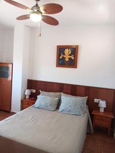 um quarto com uma cama e uma ventoinha de tecto em Pedro &Marta sol y playa em Los Urrutias