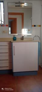 a kitchen with a sink and a mirror at Apartamento Oliva playa a escasos metros del mar in Oliva