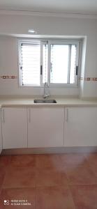 a kitchen with a sink and two windows at Apartamento Oliva playa a escasos metros del mar in Oliva