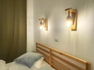 a bedroom with a bed and two lights on the wall at Cozy Riverfront Apartments with garden and mountain view in Buşteni