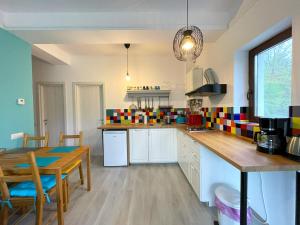 a kitchen with a table and a dining room at Cozy Riverfront Apartments with garden and mountain view in Buşteni