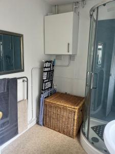 a bathroom with a shower and a basket and a sink at Field View in Oakham