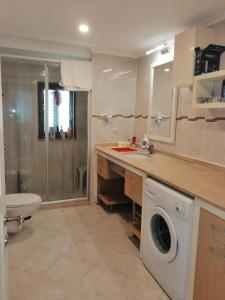 uma casa de banho com um lavatório e uma máquina de lavar roupa em villa royal em Belek