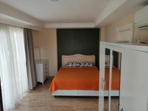 um quarto com uma cama com um cobertor laranja em villa royal em Belek