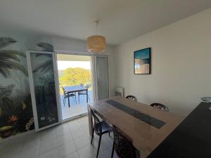a dining room with a table and a balcony at Appartement T3 - résidence de standing vue vignes in La Croix-Valmer