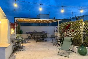 a patio with chairs and a table and a fence at La Mitria in Trani